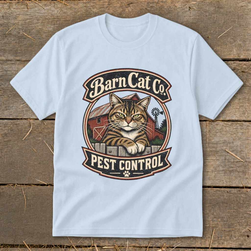 Light blue t-shirt featuring a circular graphic with a tabby cat, red barn, and Barn Cat Co. Pest Control text.