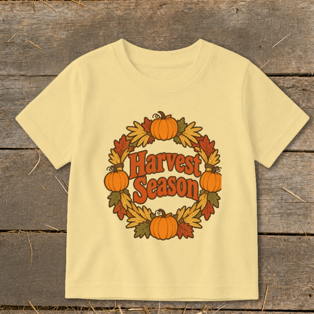 Yellow t-shirt with pumpkins, autumn leaves, and "Harvest Season" text.