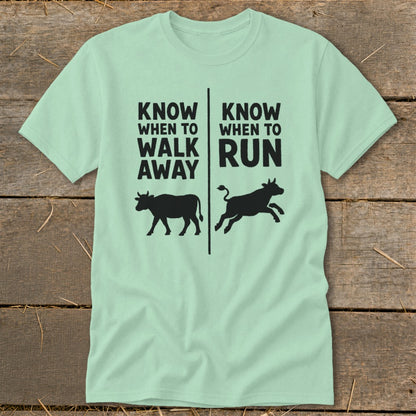 Mint t-shirt with black text "KNOW WHEN TO WALK AWAY" and "KNOW WHEN TO RUN" with cow silhouettes.