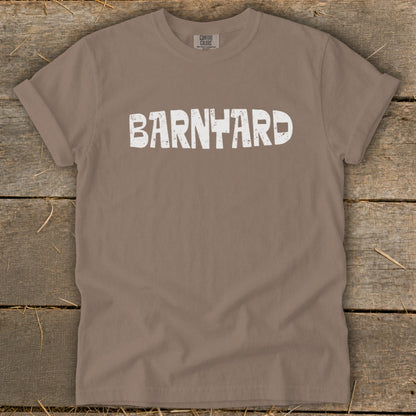 Brown crew neck t-shirt with rolled sleeves featuring the word BARNYARD in distressed white capital letters across the chest.