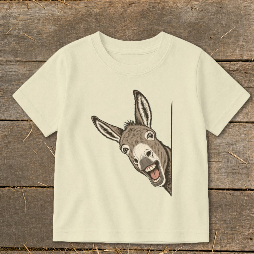 Cream t-shirt with a smiling donkey peeking from the side.