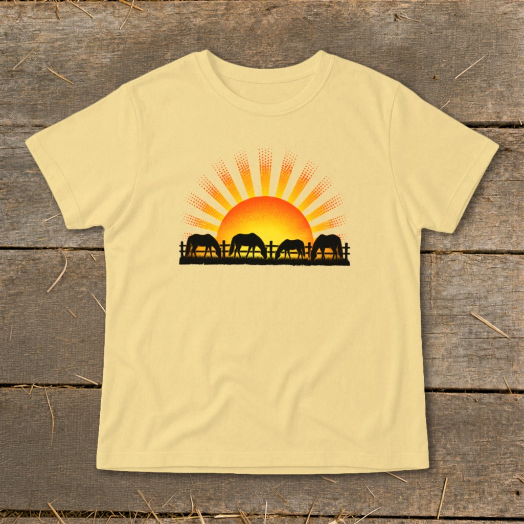 Yellow t-shirt with black silhouette of horses at sunrise graphic.