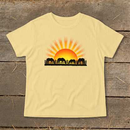 Yellow t-shirt with black silhouette of horses at sunrise graphic.