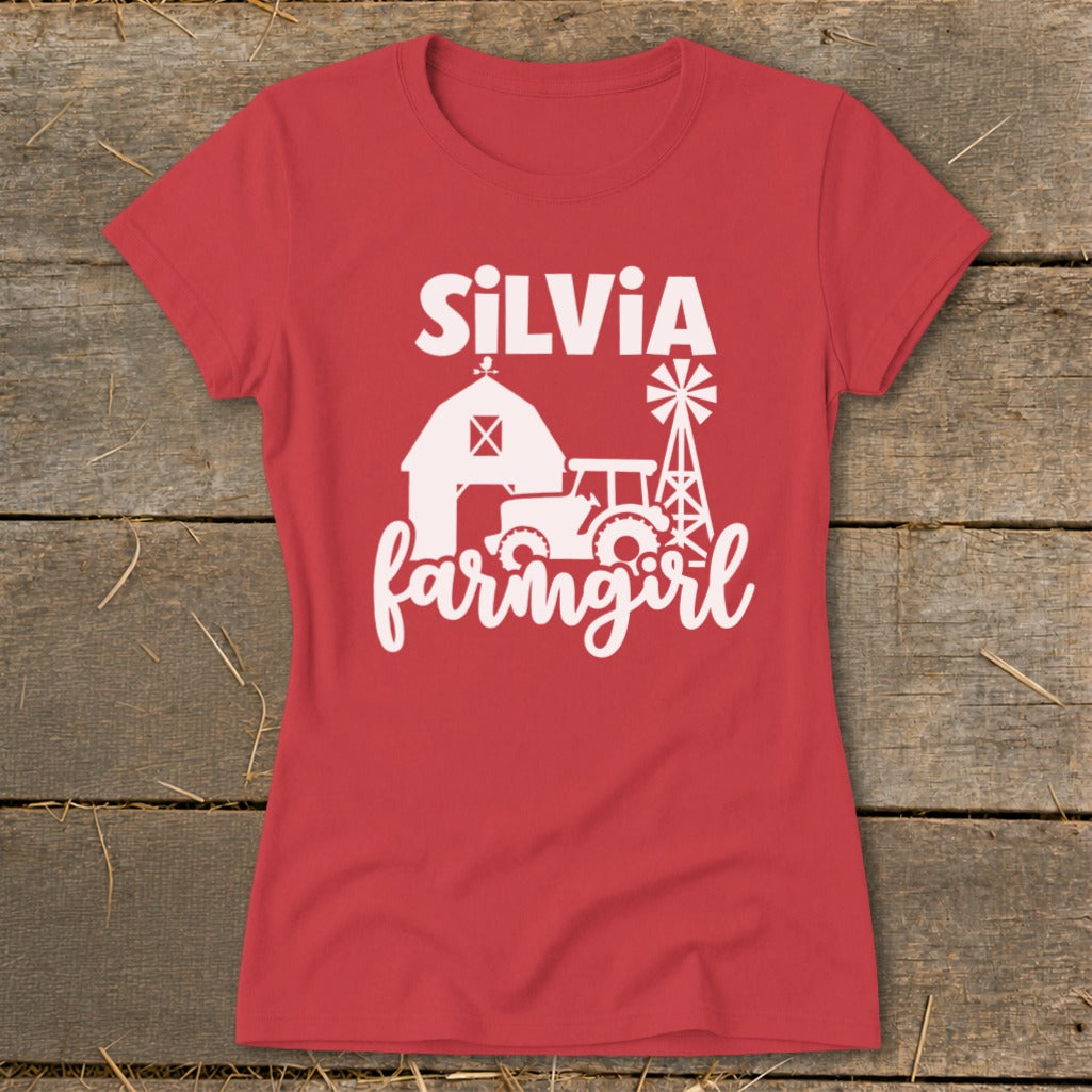 Red t-shirt with white graphic of a barn, tractor, windmill, and text "SILVIA farmingirl".