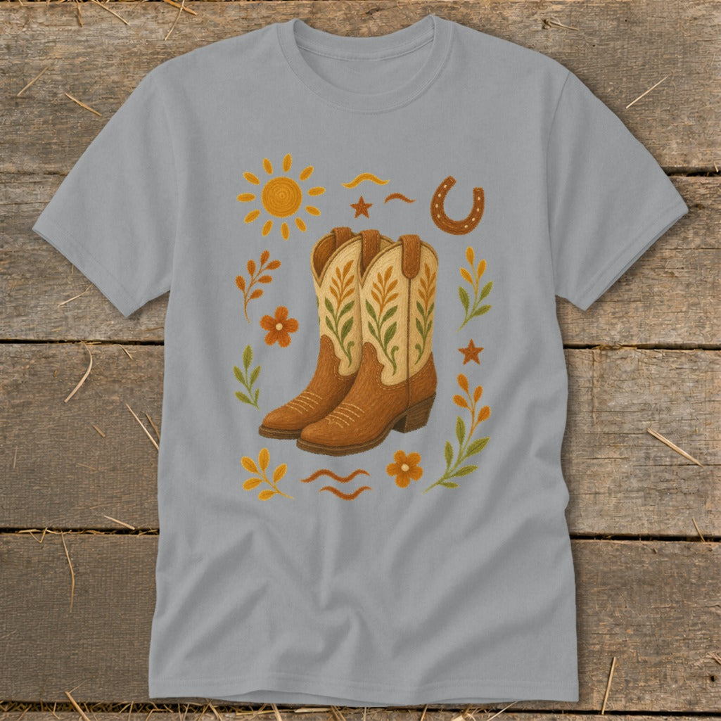 Gray t-shirt with a cowboy boot graphic surrounded by sun, horseshoe, and floral elements.