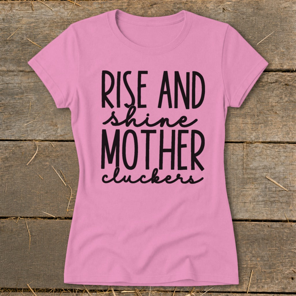Pink t-shirt with black text that reads "RISE AND shine MOTHER cluckers."
