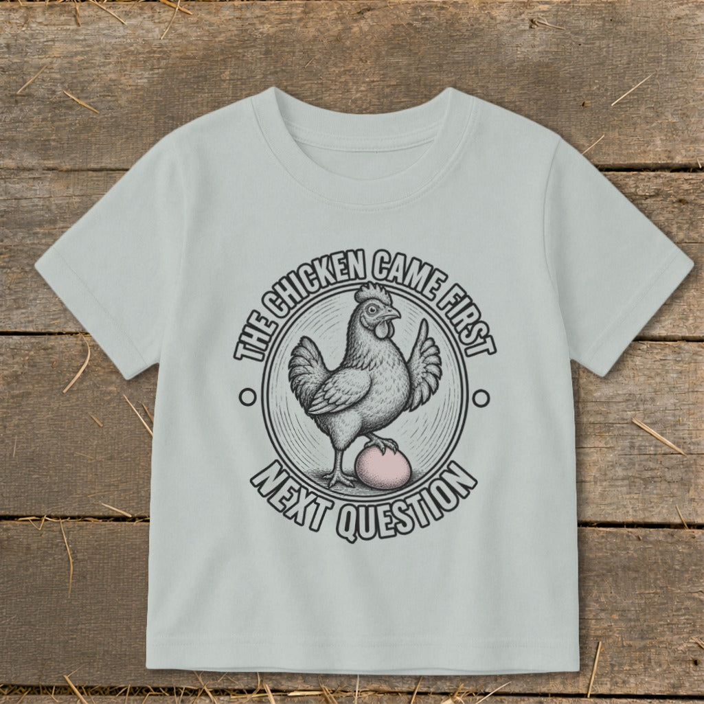 Light grey t-shirt with a chicken on an egg, text reads "The Chicken Came First. Next Question".