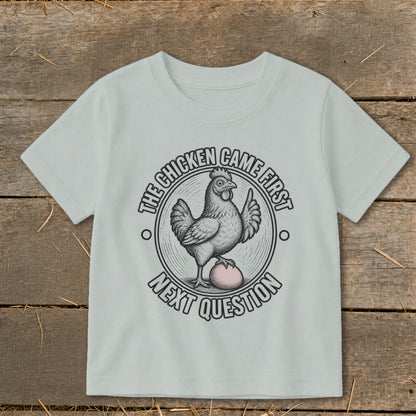 Light grey t-shirt with a chicken on an egg, text reads "The Chicken Came First. Next Question".
