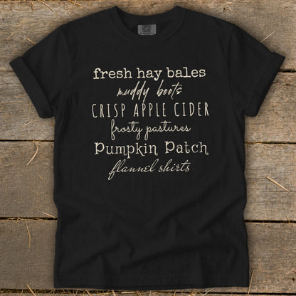 Black t-shirt with white text: "fresh hay bales, muddy boots, crisp apple cider, frosty pastures, pumpkin patch, flannel shirts."