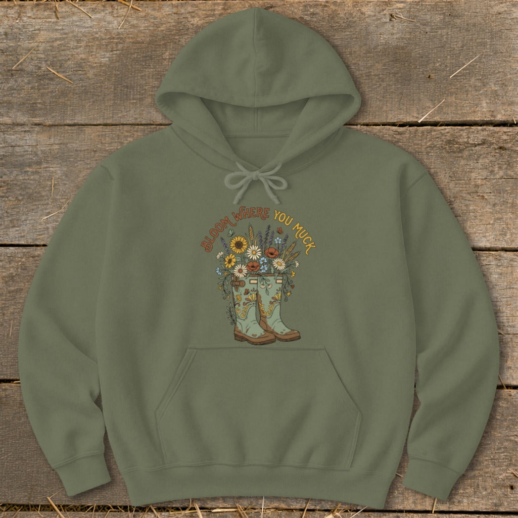 Olive green hoodie with a floral graphic and "Bloom Where You Muck" text.