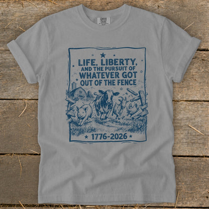 Gray t-shirt with blue graphic: "Life, Liberty, and the Pursuit of Whatever Got Out of the Fence 1776-2026".