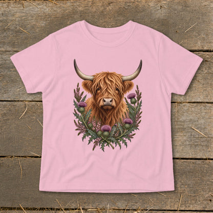 Highland cow with thistle wreath illustration on a pink t-shirt.