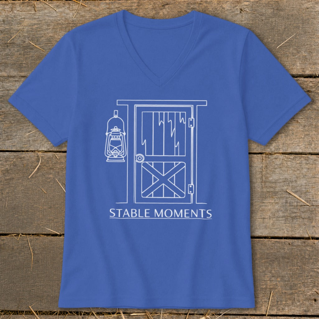 Blue v-neck t-shirt with white line art of a barn door and lantern, text reads "STABLE MOMENTS".