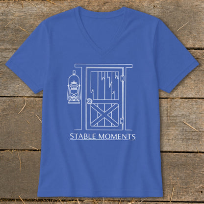 Blue v-neck t-shirt with white line art of a barn door and lantern, text reads "STABLE MOMENTS".