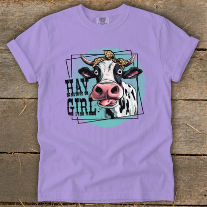 Lavender t-shirt with a graphic of a cow wearing a leopard print bandana and the text "HAY GIRL".