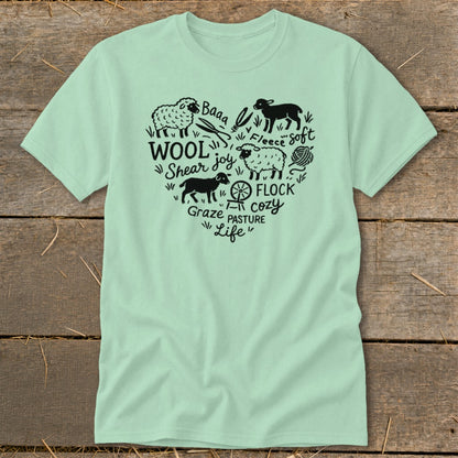 Light green t-shirt with heart-shaped black graphic of sheep, wool, and farm elements.