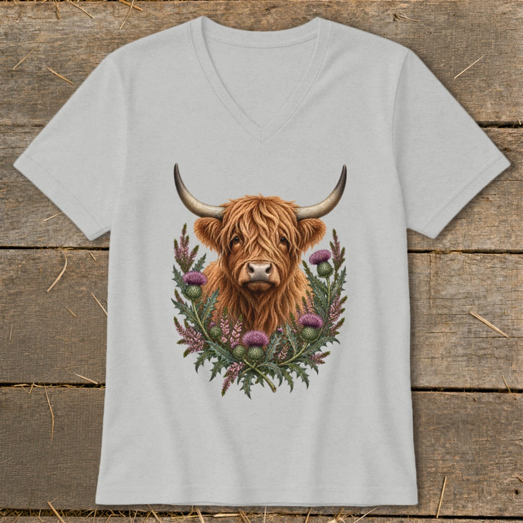 Highland cow portrait surrounded by thistles on a grey v-neck t-shirt.