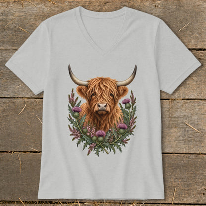 Highland cow portrait surrounded by thistles on a grey v-neck t-shirt.