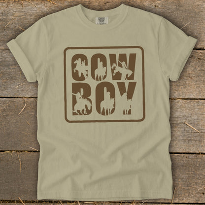 Tan t-shirt with brown "COW BOY" text and cowboy silhouettes within each letter.