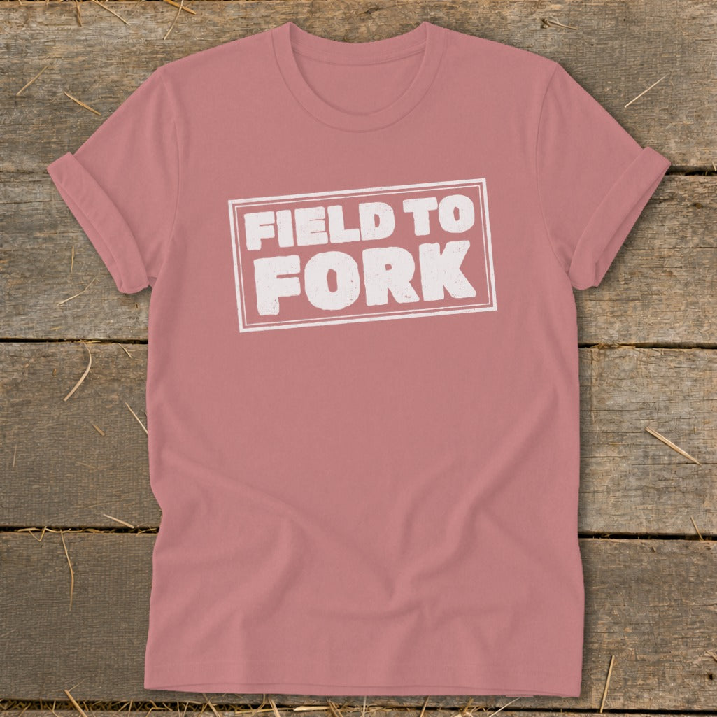 Dusty rose t-shirt with rolled sleeves displaying white text reading FIELD TO FORK inside a rectangle.