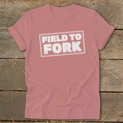 Dusty rose t-shirt with rolled sleeves displaying white text reading FIELD TO FORK inside a rectangle.
