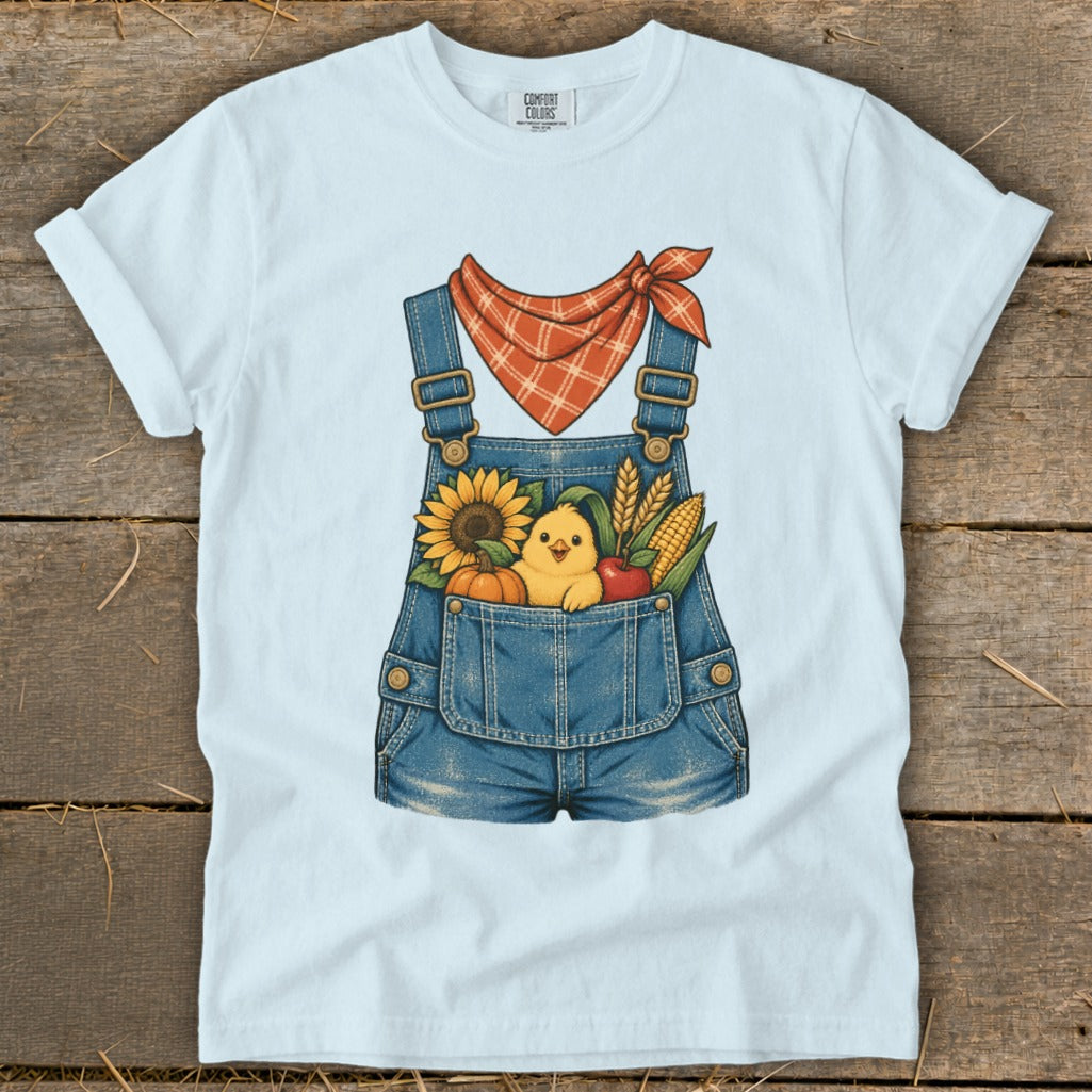 Light blue t-shirt with denim overalls graphic, featuring a chick and fall harvest items.
