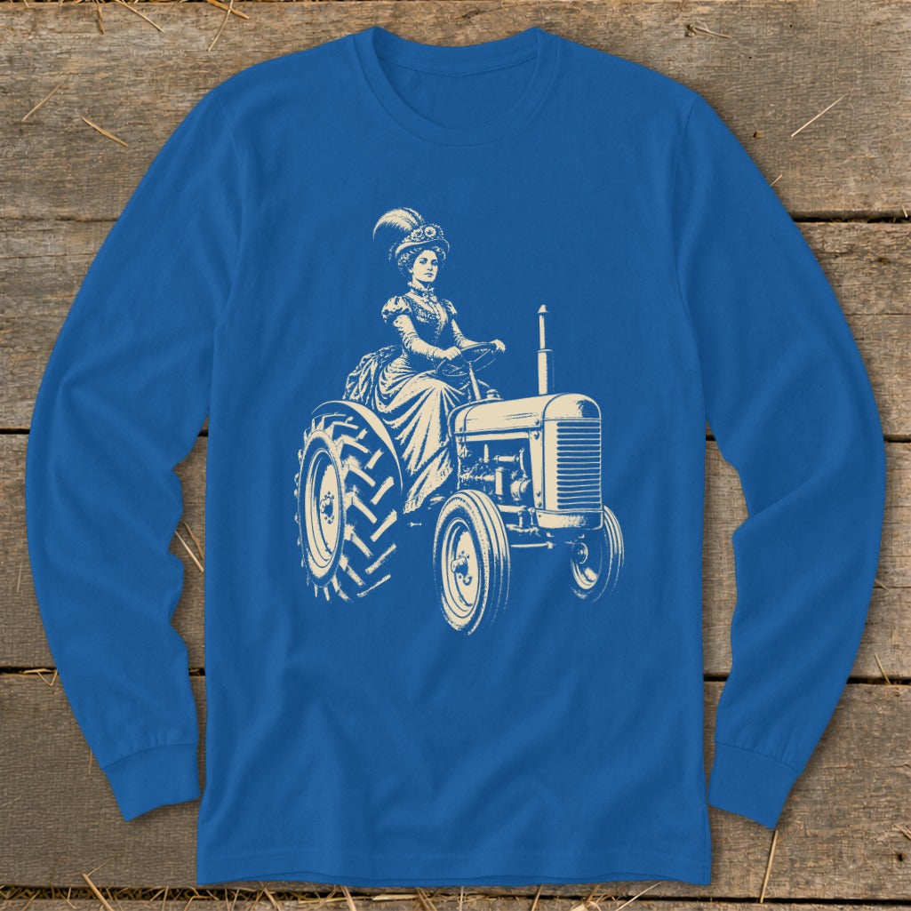 A bright blue long-sleeved shirt features a vintage graphic of a woman in a feathery hat driving a tractor.