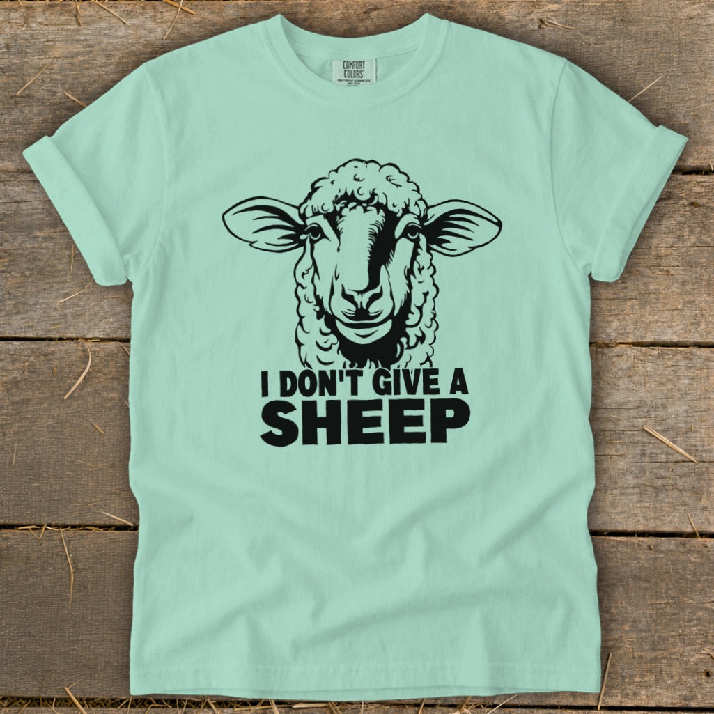 Light blue t-shirt with a black graphic of a sheep's head and text "I DON'T GIVE A SHEEP".