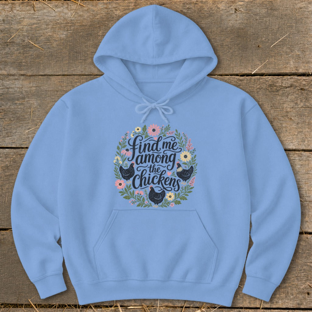 Light blue hoodie with floral wreath and "Find me among the chickens" text.