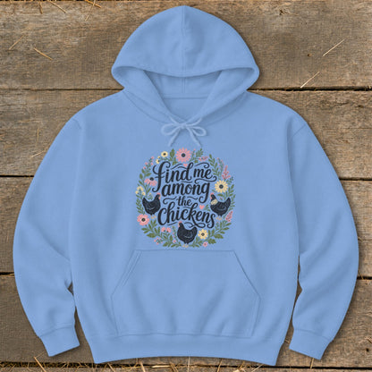 Light blue hoodie with floral wreath and "Find me among the chickens" text.