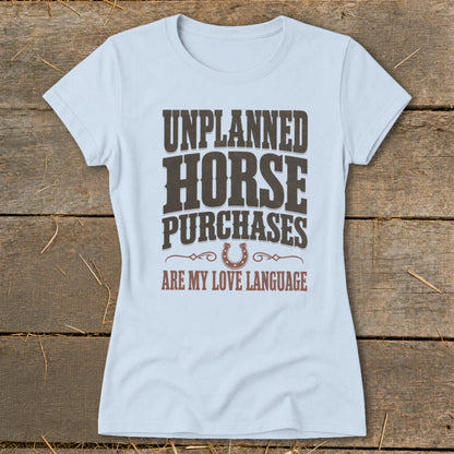 Light blue t-shirt with "Unplanned Horse Purchases Are My Love Language" text and horseshoe.