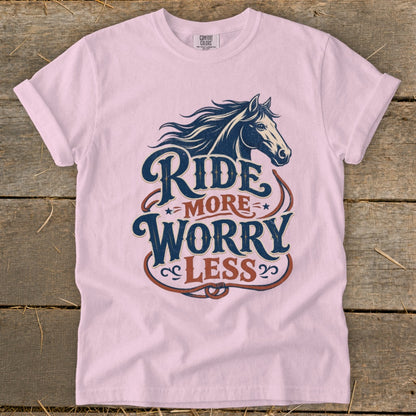 Pink t-shirt with graphic of horse and text "Ride More Worry Less."