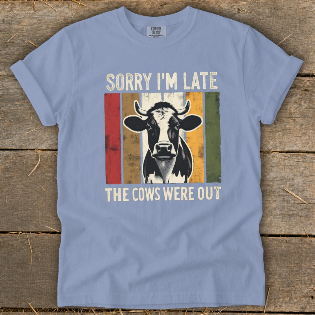 T-shirt with a black and white cow graphic and text that reads "SORRY I'M LATE THE COWS WERE OUT".
