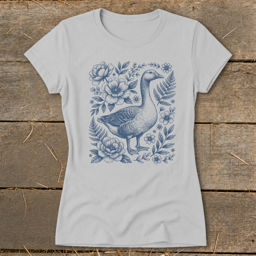 Light grey t-shirt with a blue ink drawing of a goose surrounded by flowers and ferns.