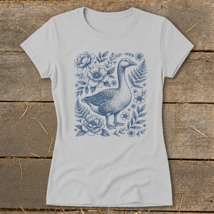 Light grey t-shirt with a blue ink drawing of a goose surrounded by flowers and ferns.