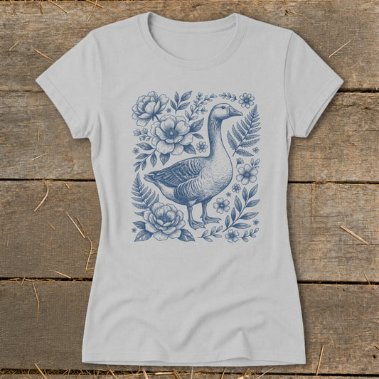 Light grey t-shirt with a blue ink drawing of a goose surrounded by flowers and ferns.