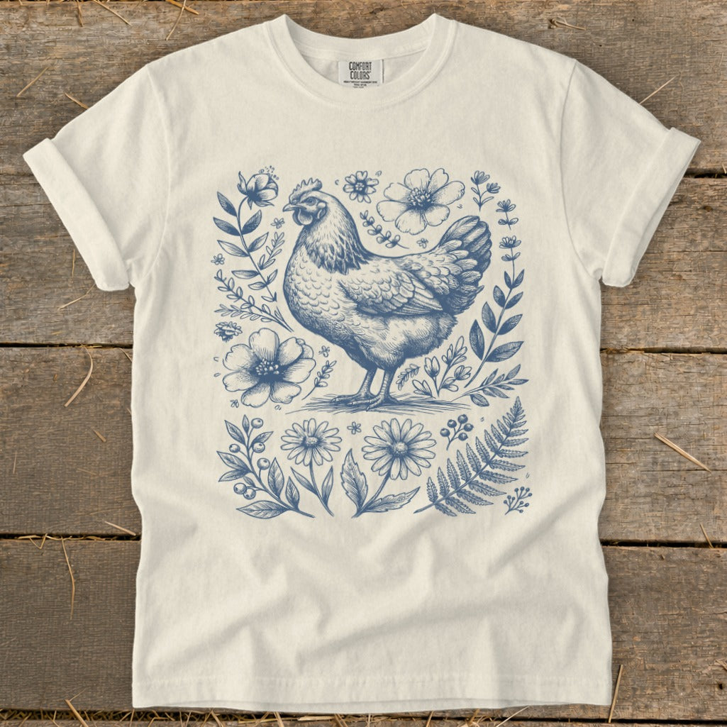 Cream t-shirt with a vintage-style blue line drawing of a hen and floral elements.