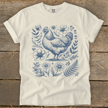 Cream t-shirt with a vintage-style blue line drawing of a hen and floral elements.