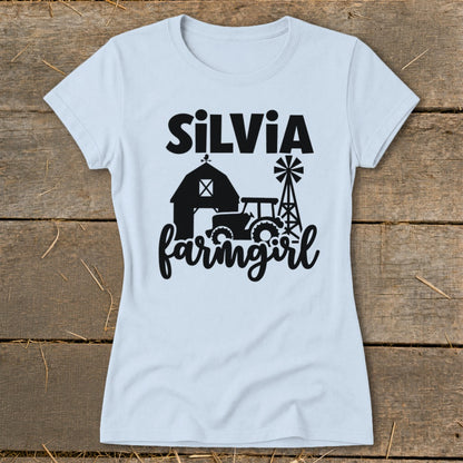 Light blue t-shirt with black "SiLVia farmgirl" text, barn, tractor, and windmill graphic.