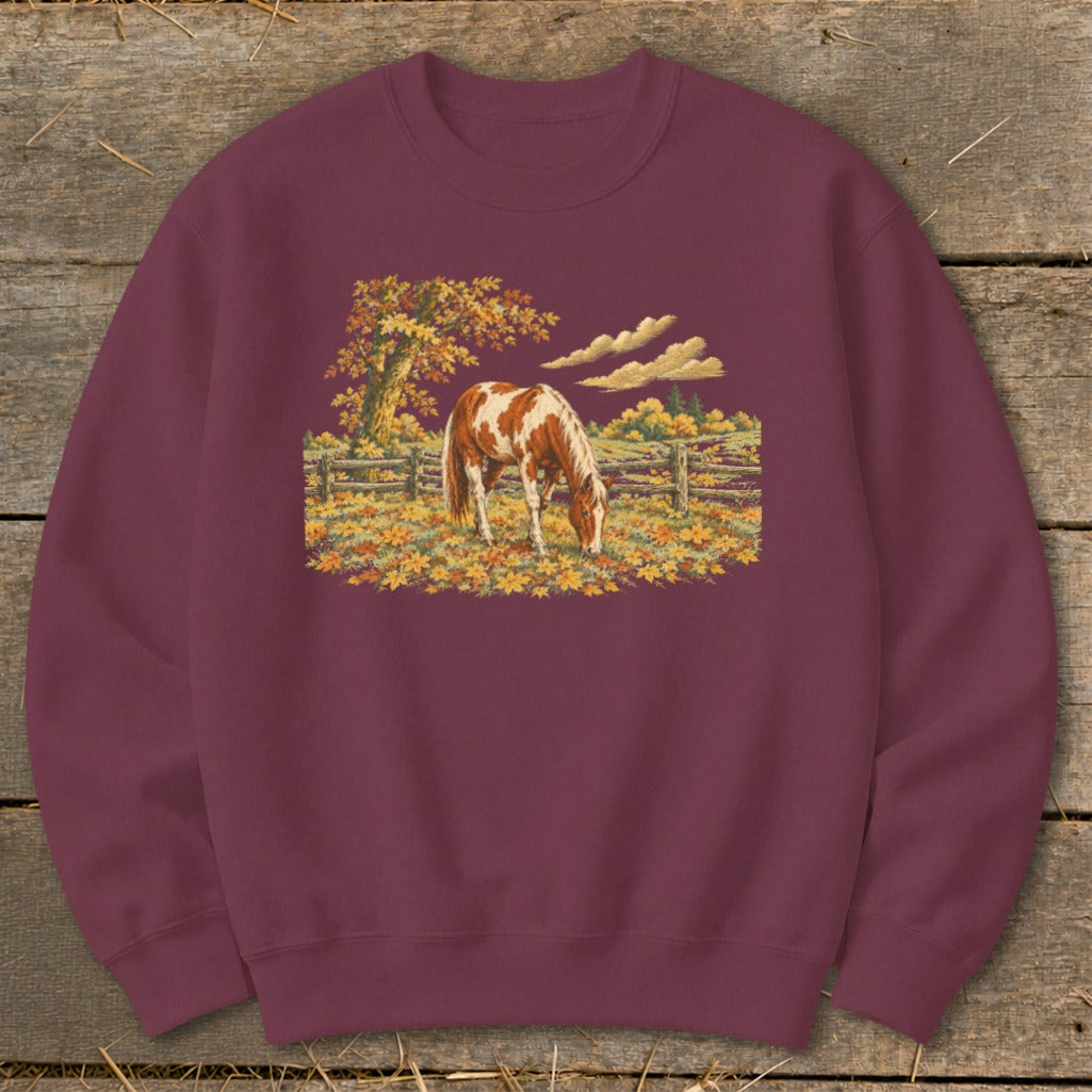 Maroon sweatshirt with a painted autumnal scene of a brown and white horse grazing.