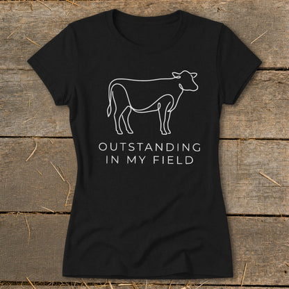 Black t-shirt with white line art of a cow and the text "OUTSTANDING IN MY FIELD".