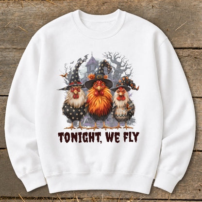 Three chickens in witch hats stand before a spooky haunted house, text reads "TONIGHT, WE FLY".
