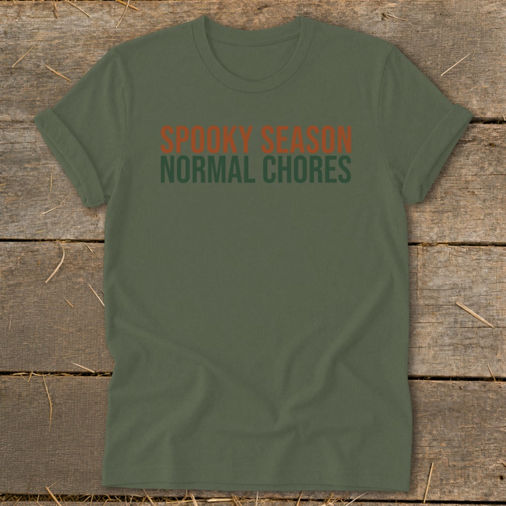 Olive green t-shirt with orange text: Spooky Season, green text: Normal Chores.