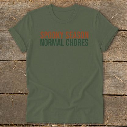 Olive green t-shirt with orange text: Spooky Season, green text: Normal Chores.