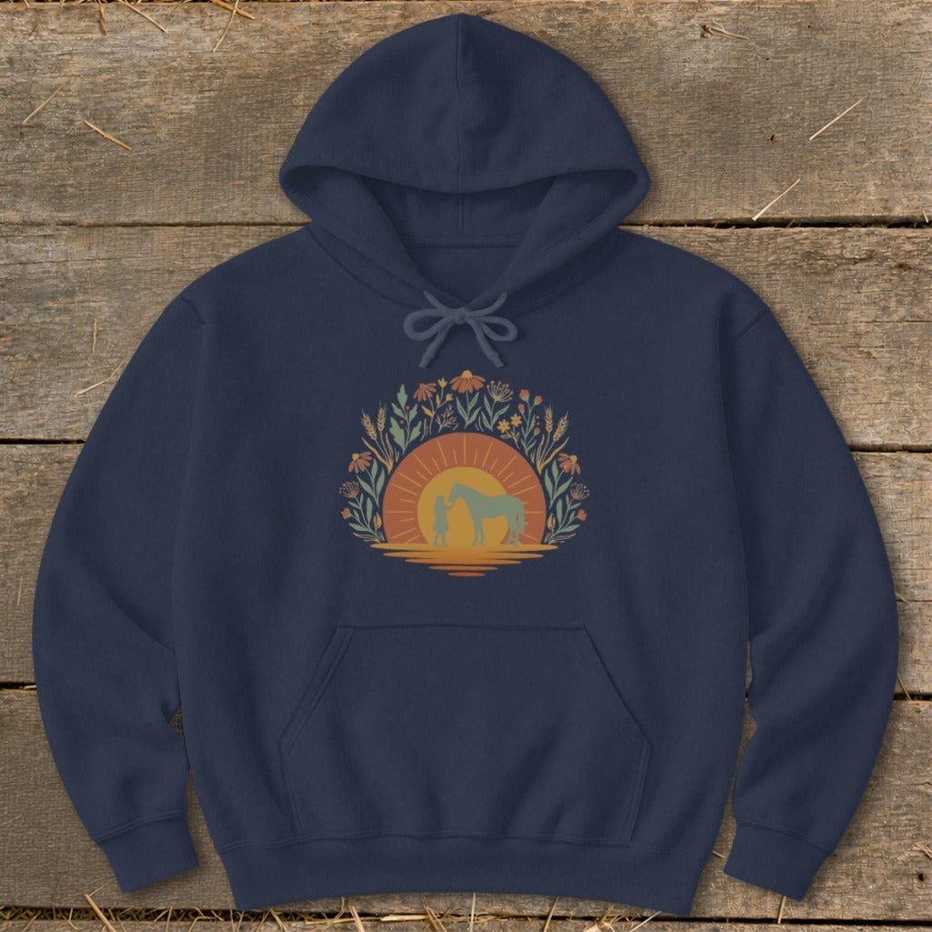 Navy hoodie with a graphic of a person and horse against a sunset surrounded by wildflowers.