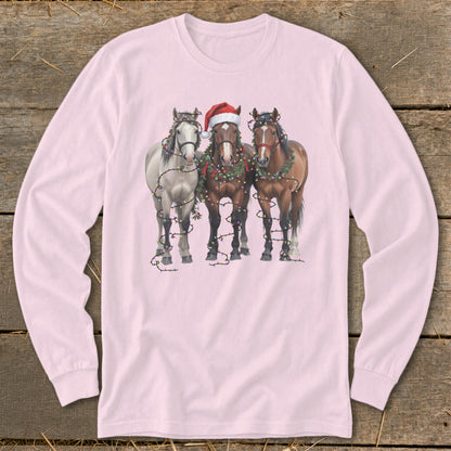 Three horses wearing Santa hats and Christmas lights are printed on a pink long-sleeved shirt.