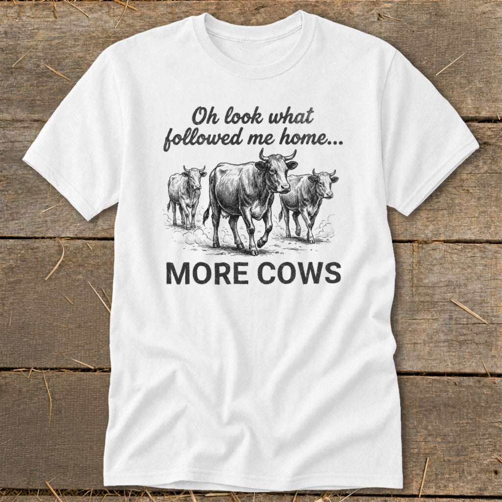 White t-shirt with sketch of three cows and text "Oh look what followed me home... MORE COWS".