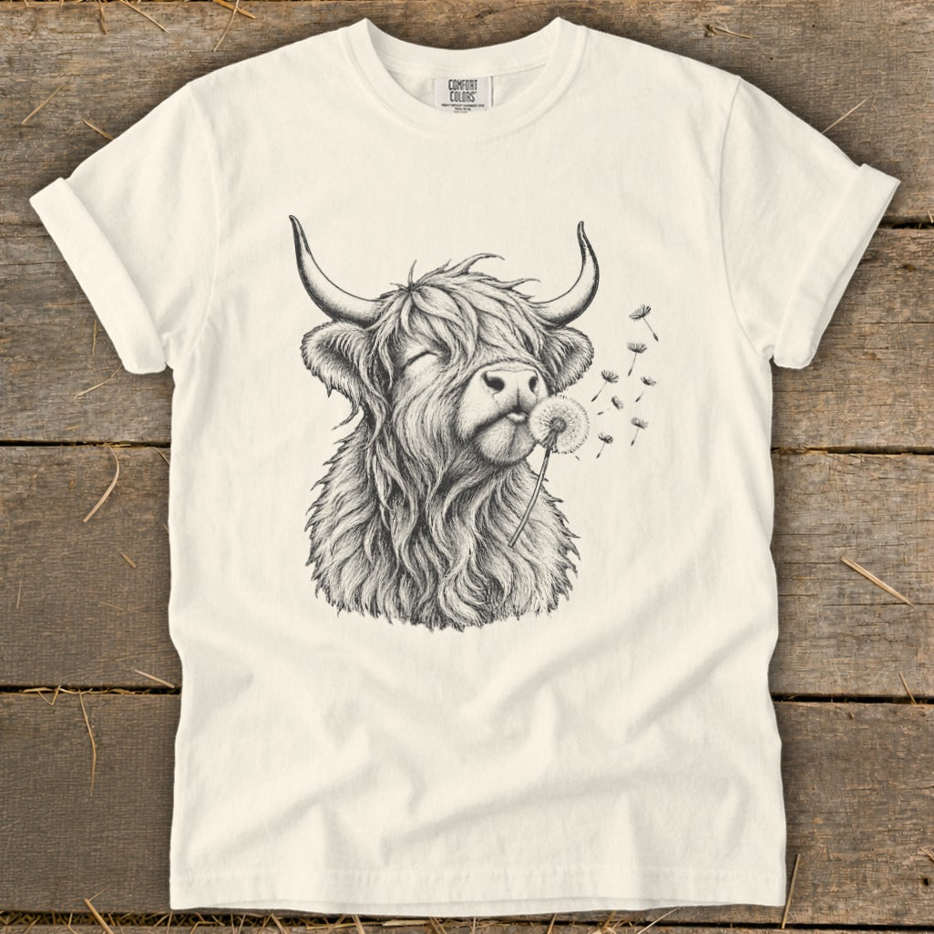 T-shirt with sketch of Highland cow blowing dandelion seeds.