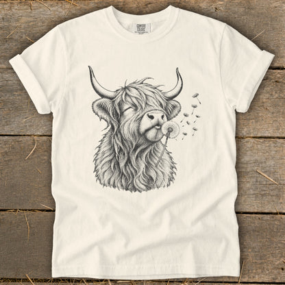 T-shirt with sketch of Highland cow blowing dandelion seeds.