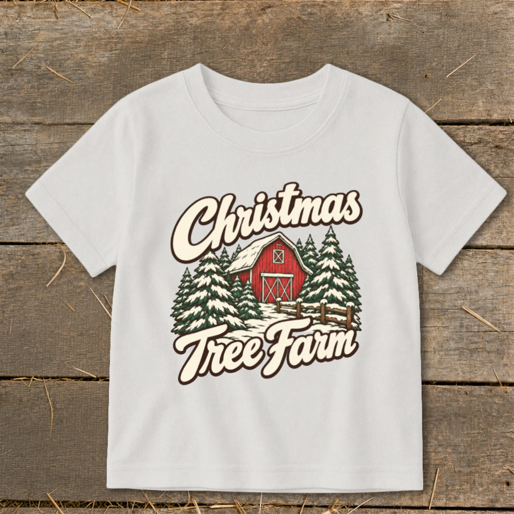 White t-shirt with "Christmas Tree Farm" text and a red barn and trees graphic.